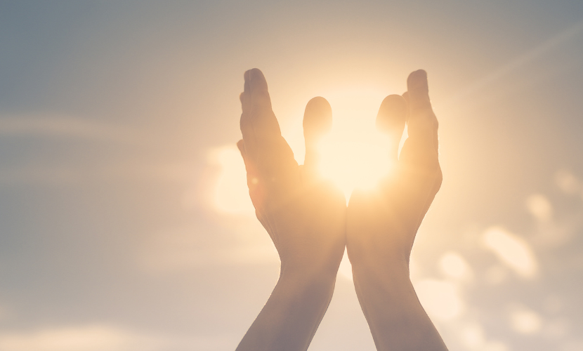 光が輝き手をかざしているイメージ